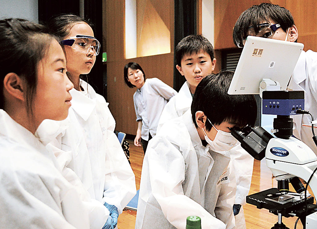 顕微鏡を使って微生物を観察する児童＝長泉町のコミュニティながいずみ