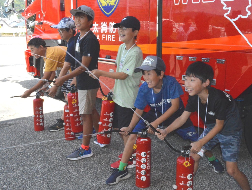 水消火器の使用を体験する児童＝藤枝市の藤枝消防署