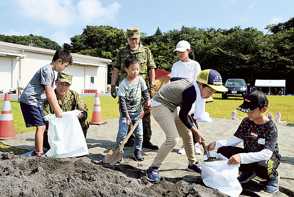 土のう作りに取り組む児童たち＝袋井市豊沢の豊沢の丘防災広場