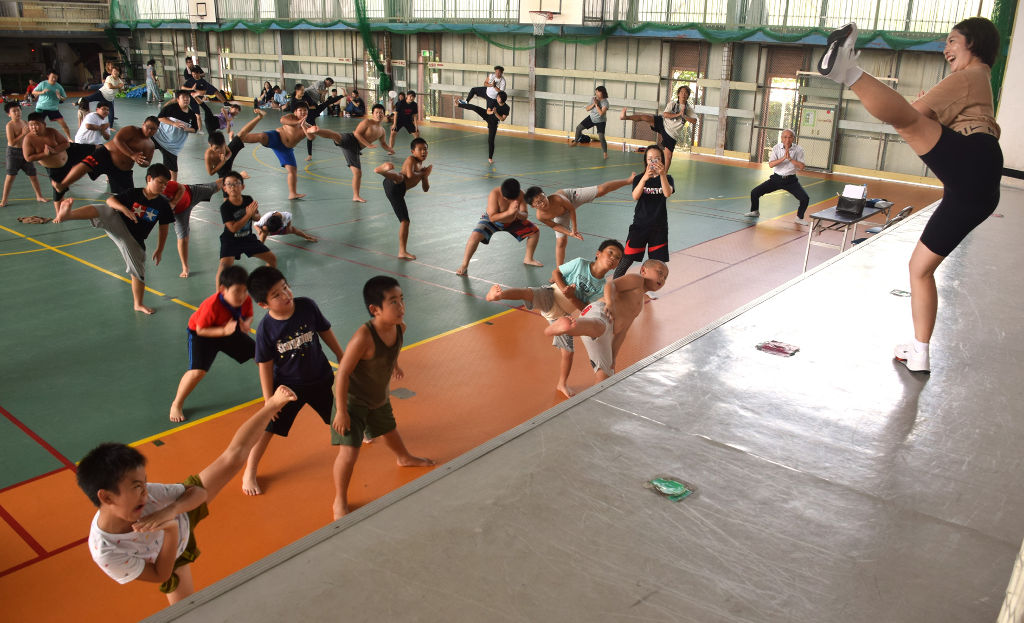 相撲の動きを取り入れたトレーニングで汗を流す参加者＝焼津市の焼津体育館
