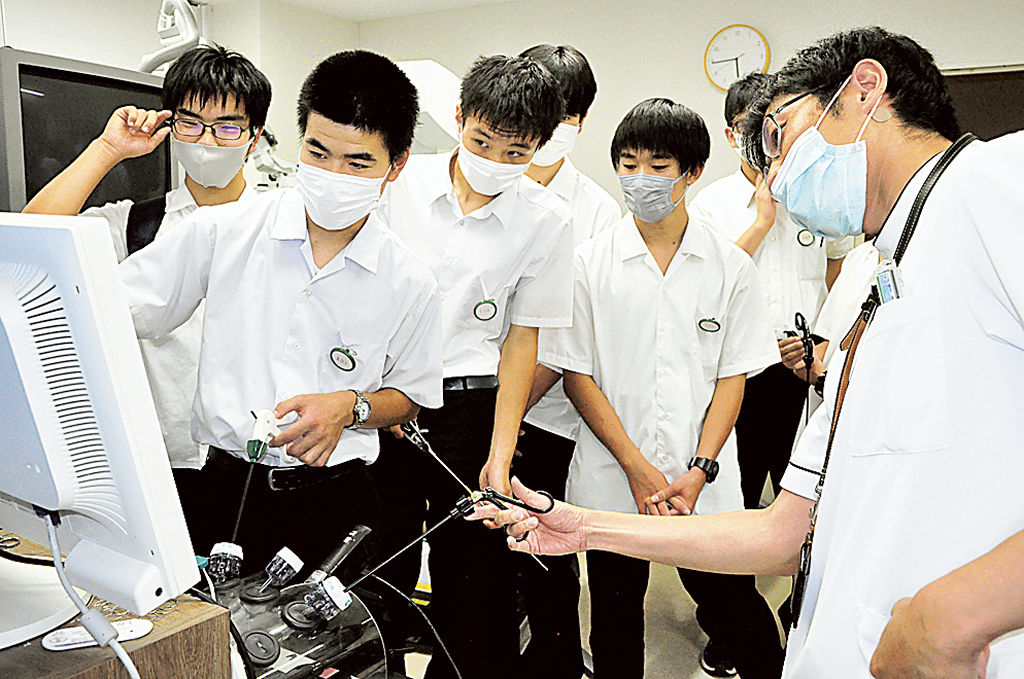 腹腔鏡手術のトレーニングを体験する生徒＝長泉町の県立静岡がんセンター