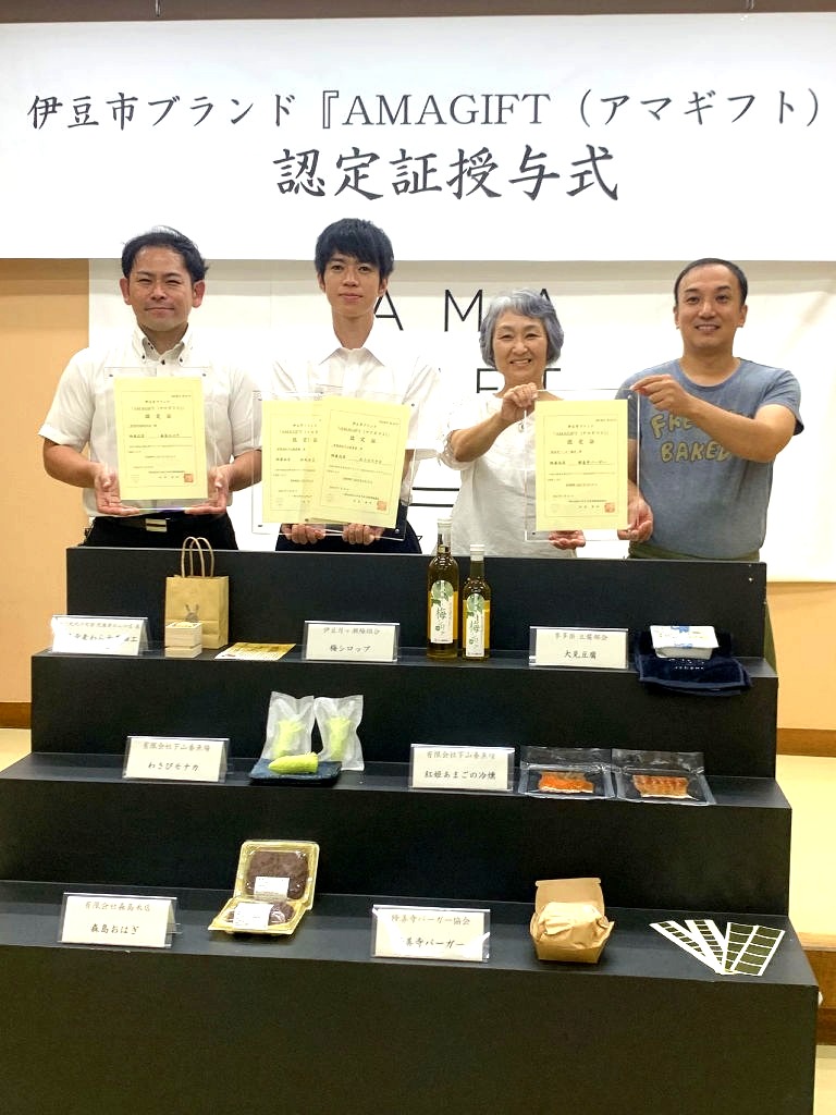 新たに認定された「ＡＭＡＧＩＦＴ（アマギフト）」の商品と認定証を持つ出席者＝伊豆市の修善寺総合会館