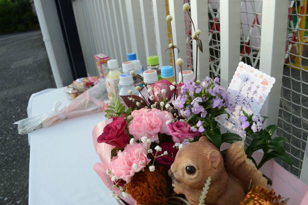 川崎幼稚園の園舎の前に設置された献花台には５日を前に既に多くの飲み物や花束が添えられていた＝３日、牧之原市静波