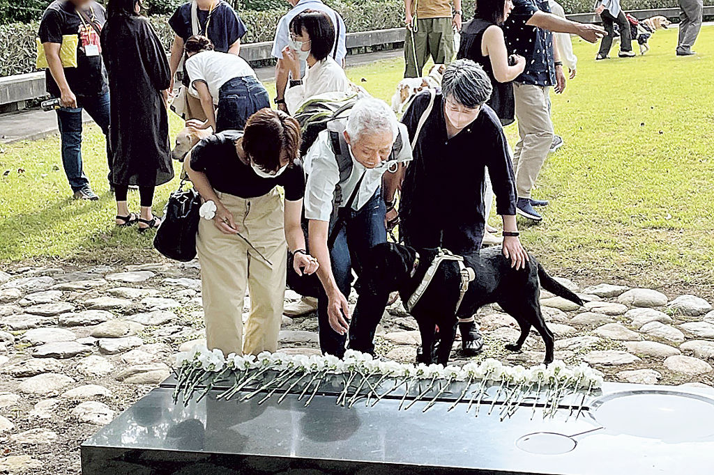 慰霊碑に献花する盲導犬ユーザー＝富士宮市の富士ハーネス