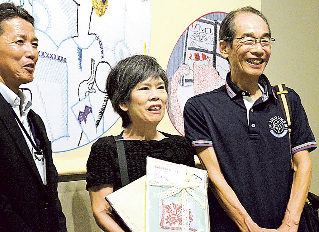 １万人目となった木俣さん（中央）と松村さん（右）＝静岡市駿河区の県立美術館