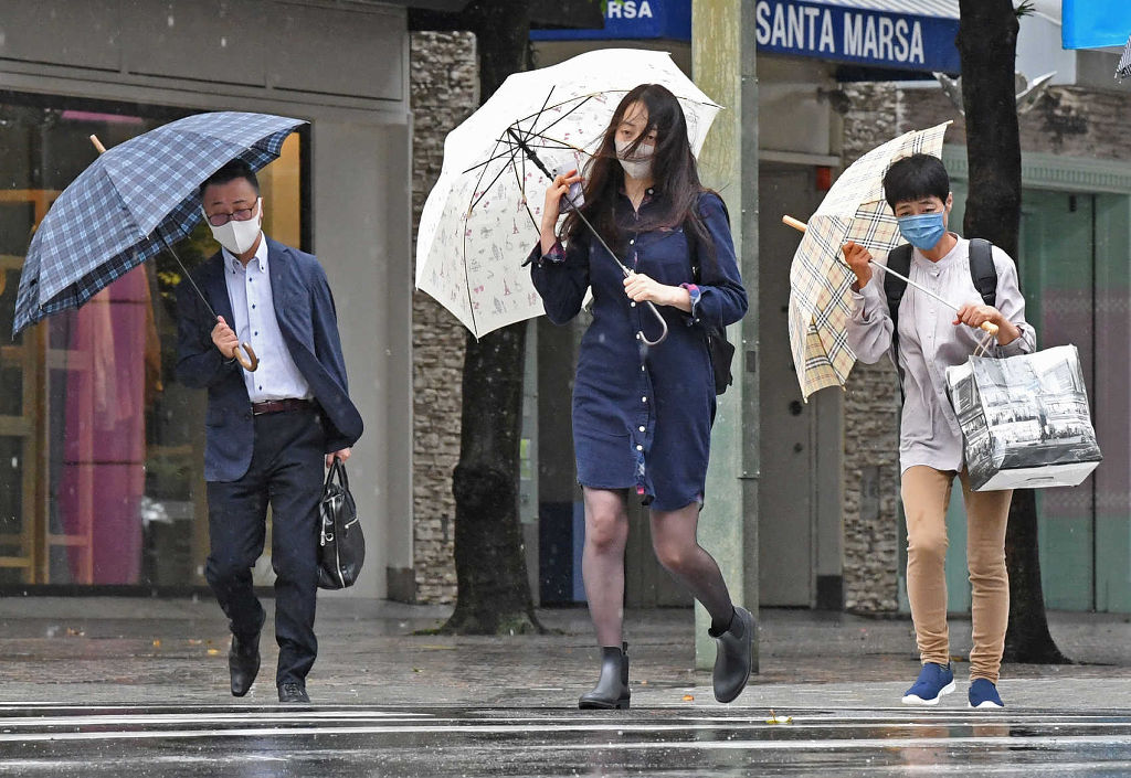 傘が飛ばされないようにして歩く人々を写して強風を表現した（２０２１年９月、静岡新聞掲載）