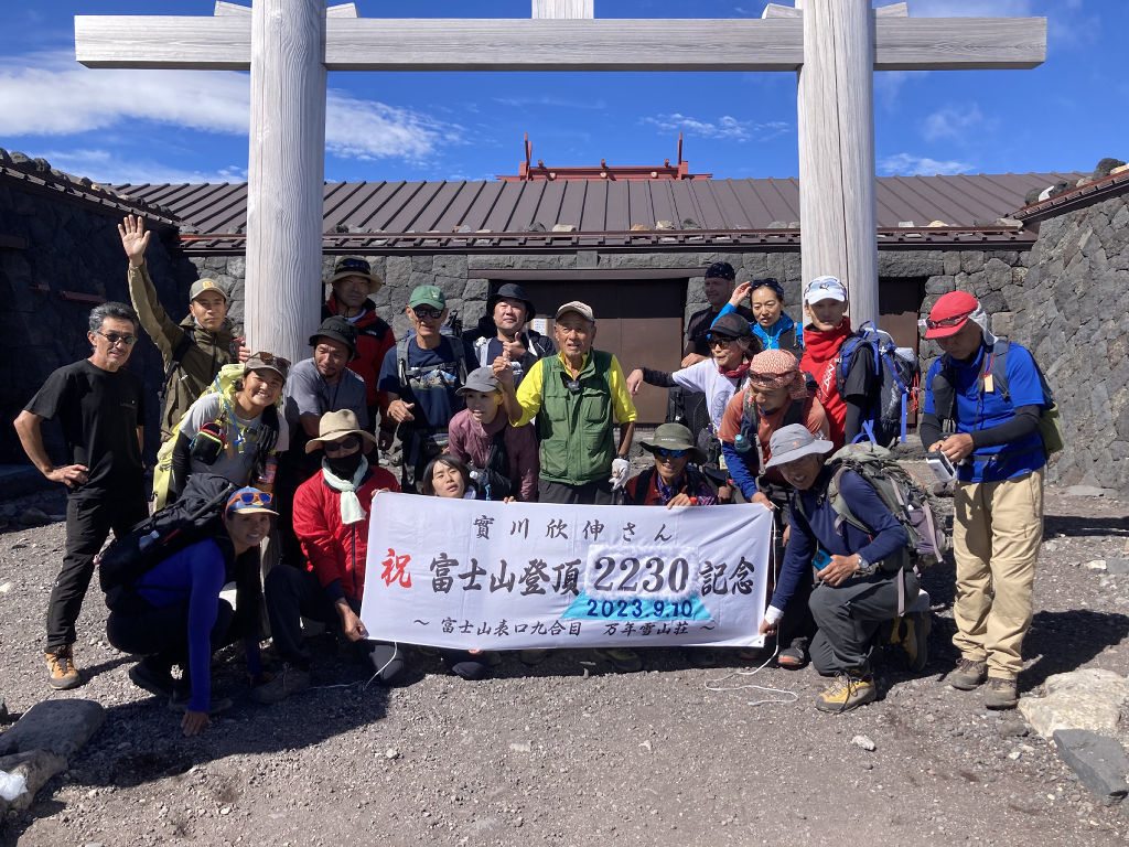 ２２３０回目の富士山登頂を達成した実川さん（中央）＝１０日午後、富士山（本人提供）