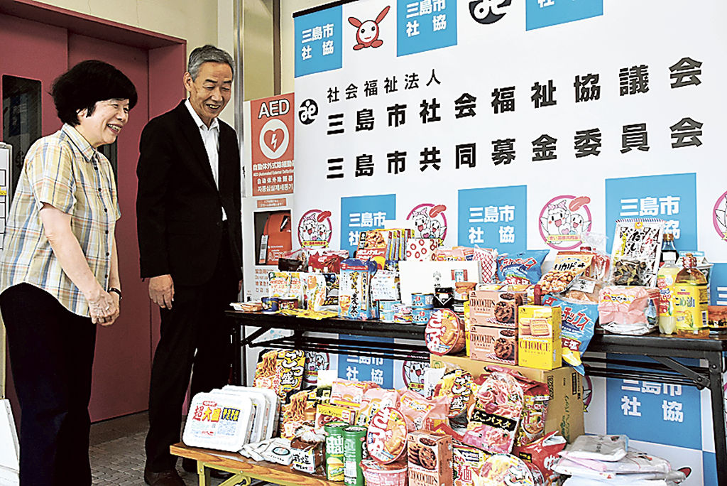 会員から集めた食料品について中村会長(右)に説明する遠藤会長=三島市社会福祉協議会