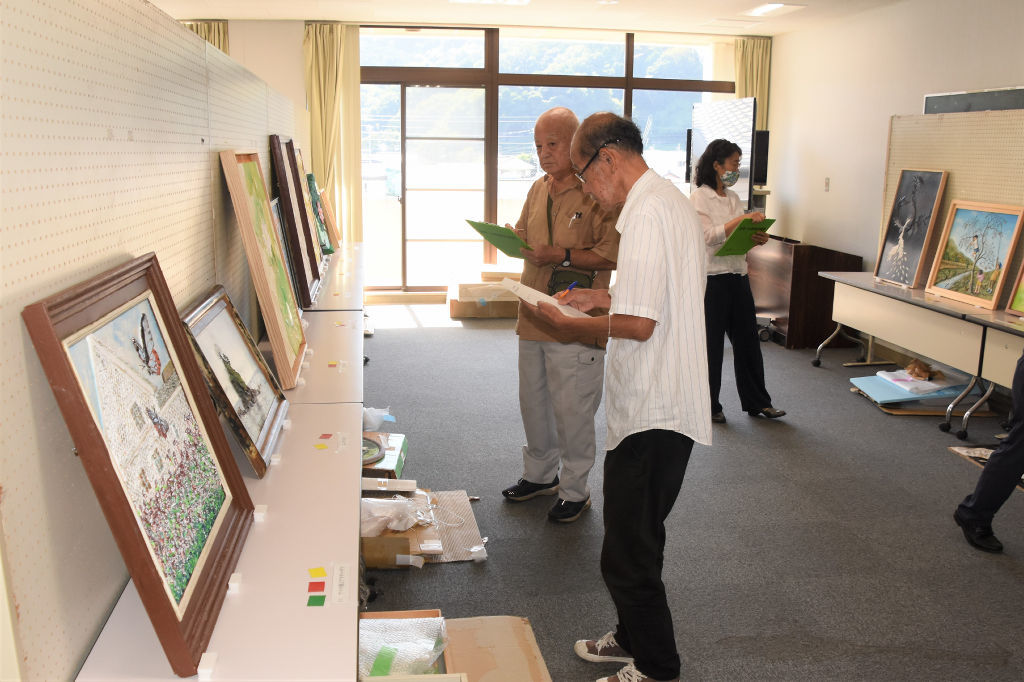 漆喰鏝絵の作品を確認する審査員＝松崎町の町環境改善センター