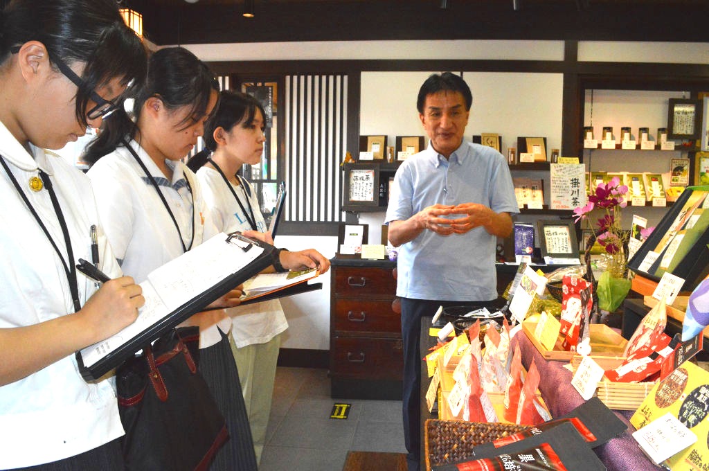 松田社長（右）から商品の説明を受けるメンバー＝藤枝市茶町の真茶園