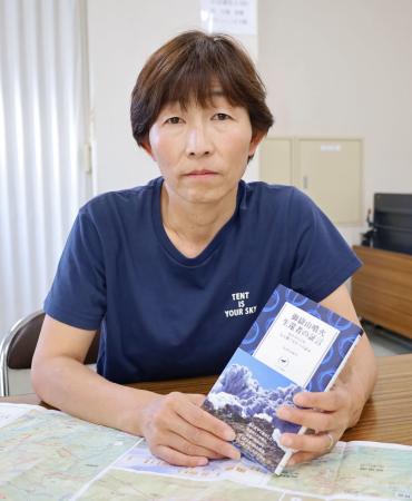 生還者の証言をまとめて出版した本を手にする小川さゆりさん＝３日、長野県駒ケ根市