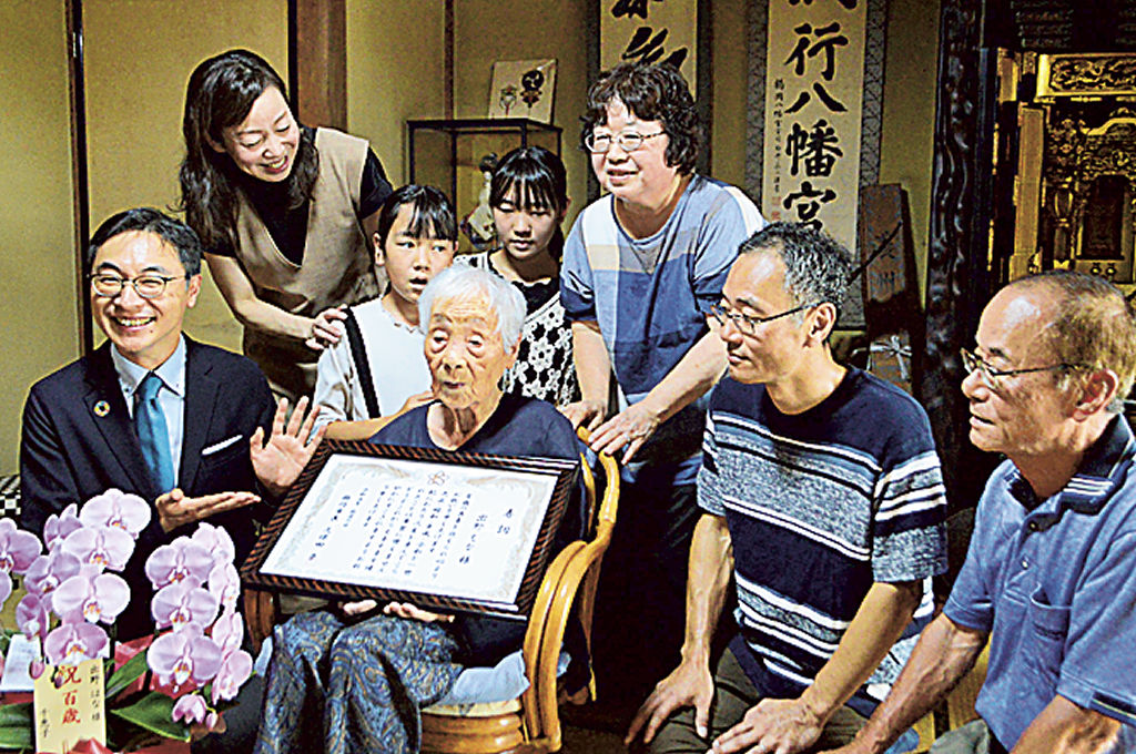 長寿を祝う久保田市長（左）と家族と一緒に写真に収まるはなさん（左から４人目）＝掛川市千浜
