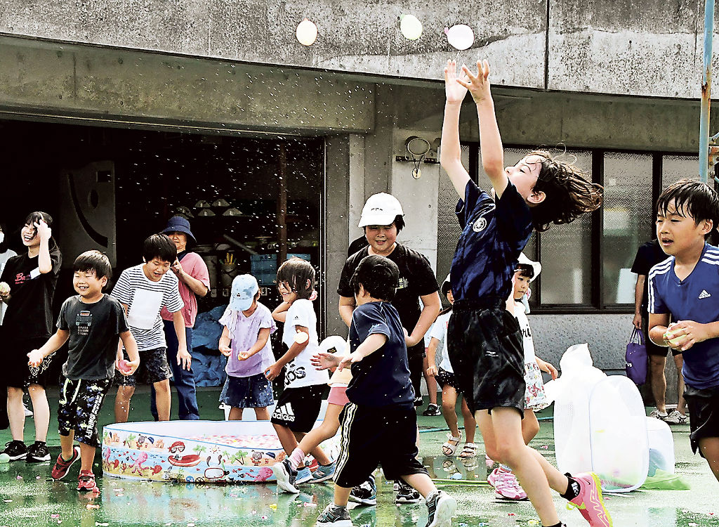 びしょぬれになって水風船投げを楽しむ子どもたち＝御殿場市の市陸上競技場