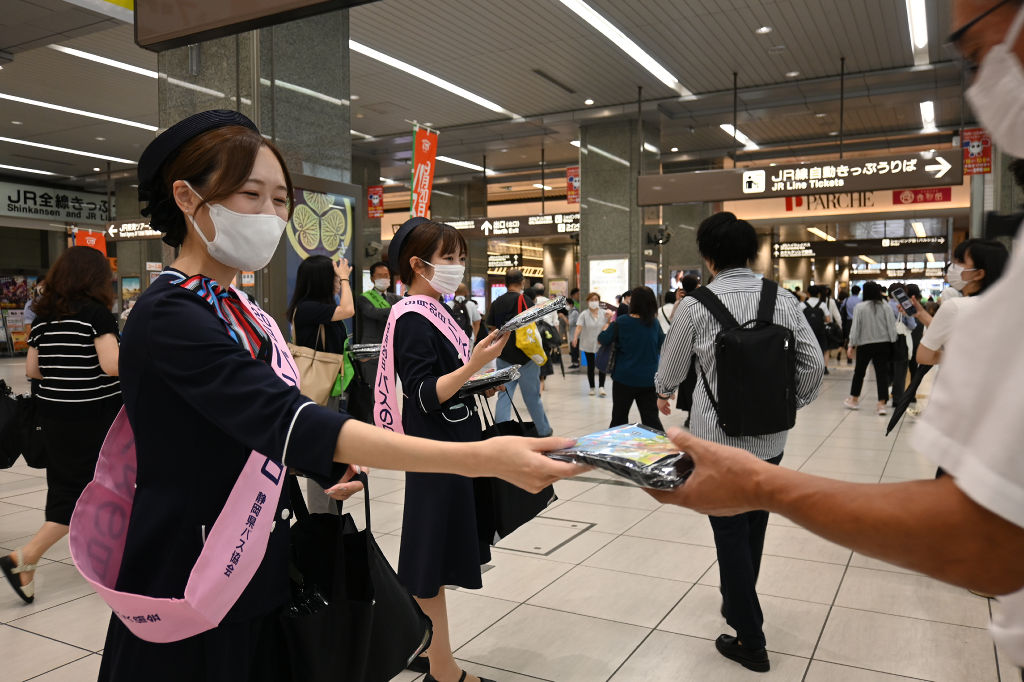 通行人に啓発品のトートバッグを配布するキャンペーン参加者＝ＪＲ静岡駅コンコース