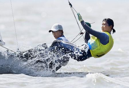 杭州アジア大会のセーリング混合４７０級で艇を操る岡田奎樹（左）、吉岡美帆組。優勝を決めた＝２６日、中国・寧波（共同）
