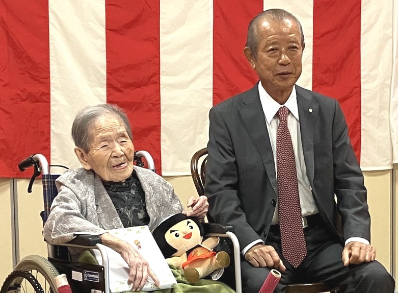 静岡県内最高齢として込山町長（右）から記念品を受け取った臼井さん＝御殿場市の特別養護老人ホーム白雪