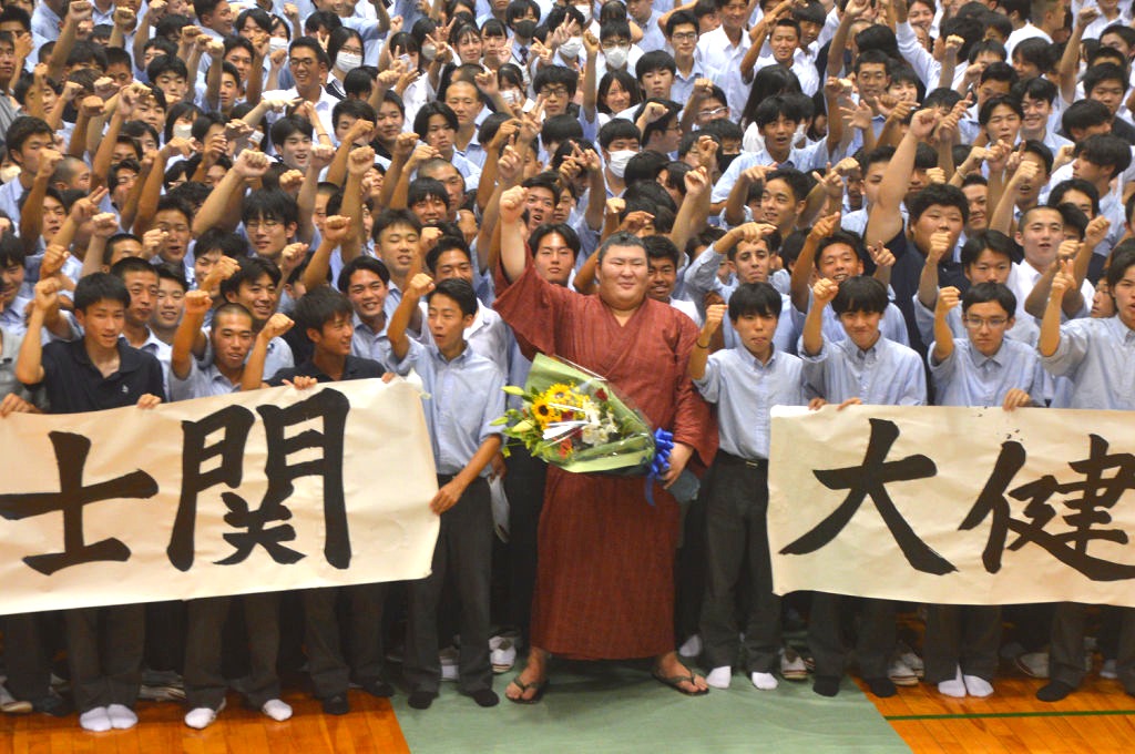 約７５０人の生徒に出迎えられ、記念撮影する熱海富士（手前中）＝２９日午後、沼津市の飛龍高