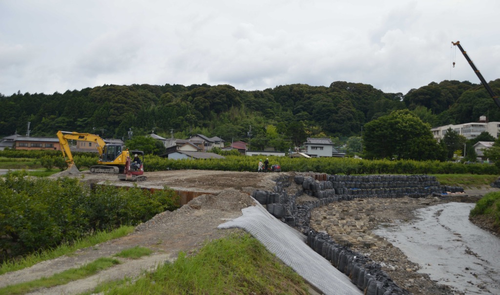 鋼矢板を土に埋める最終作業が進められている敷地川の決壊箇所＝７月上旬、磐田市