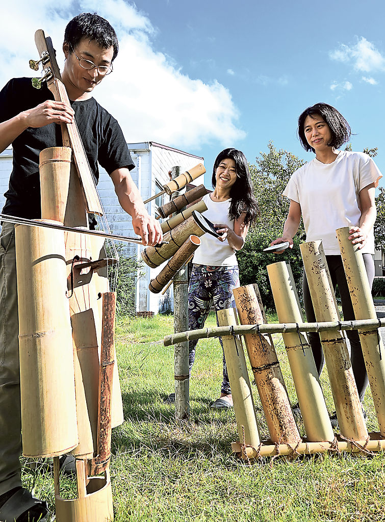 竹の有効活用として考案した「竹チェロ」を演奏する原さん（左）＝静岡市葵区古庄のひかり市民センター前