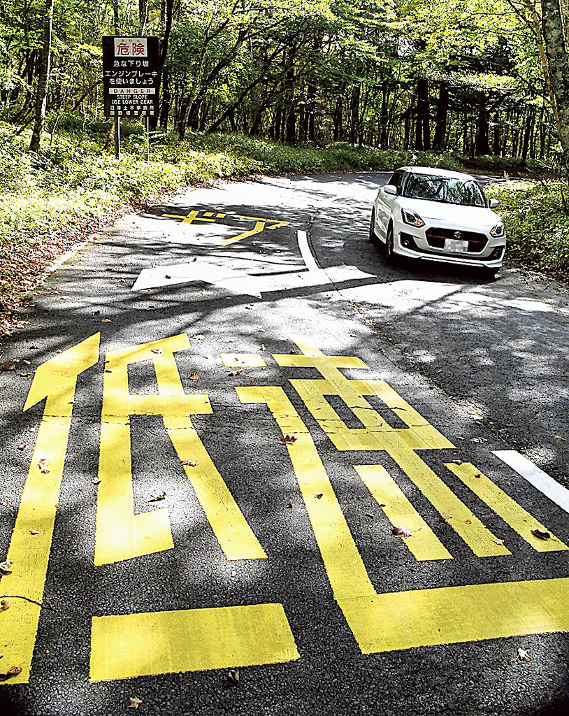 エンジンブレーキの使用などを啓発する看板や路面標示が設置された「ふじあざみライン」＝１２日午前、小山町須走（写真の一部を加工しています）
