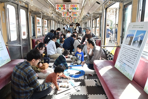 おもちゃと絵本が並べられた電車内で遊ぶ来場者＝富士市の岳南江尾駅