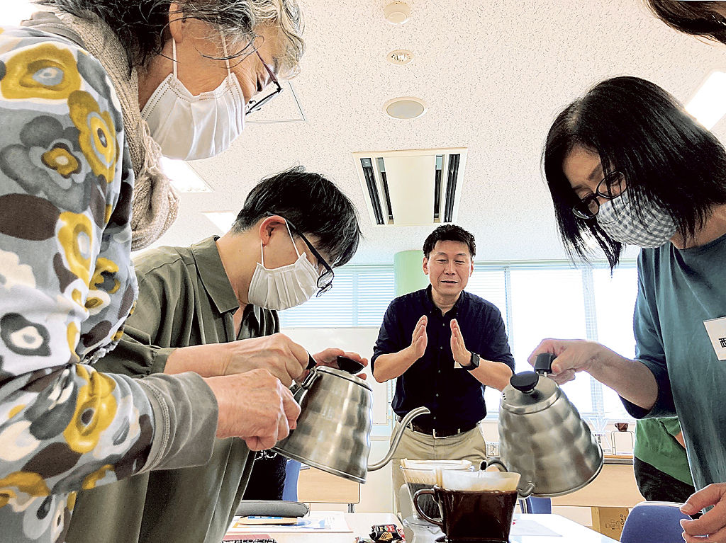 伊藤さん（左から３番目）の解説を受けながら、コーヒー抽出に挑戦する参加者＝御前崎市