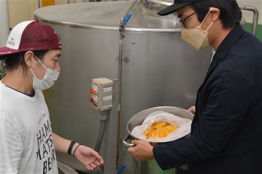 浜松産グレープフルーツの果皮で仕込み作業をする石川代表（右）と杉本さん＝浜松市中区
