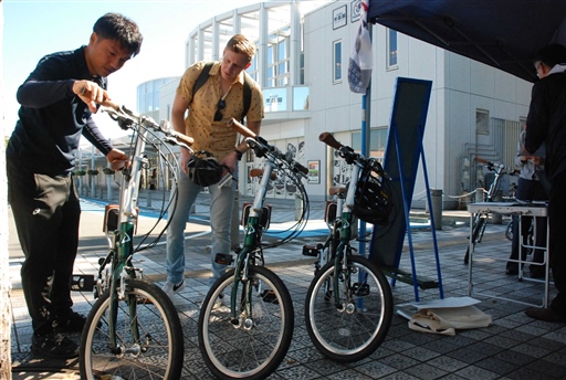 ＪＲ富士駅までの移動に自転車を借りる利用者（右）＝１６日、富士市の新富士駅北口