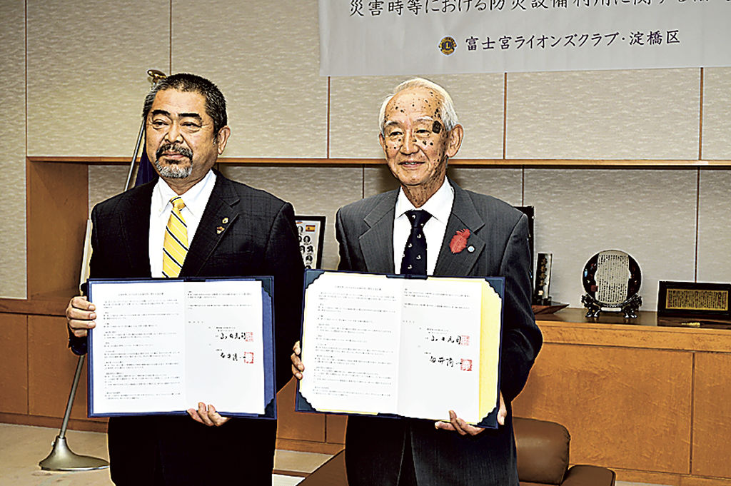 協定書を交わした山田会長（左）と白井区長＝富士宮市役所