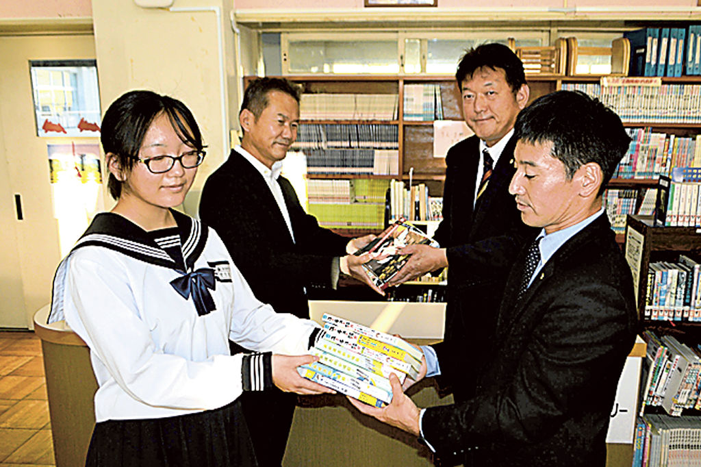 本を受け取る望月図書副委員長（左）＝菊川市加茂の菊川西中