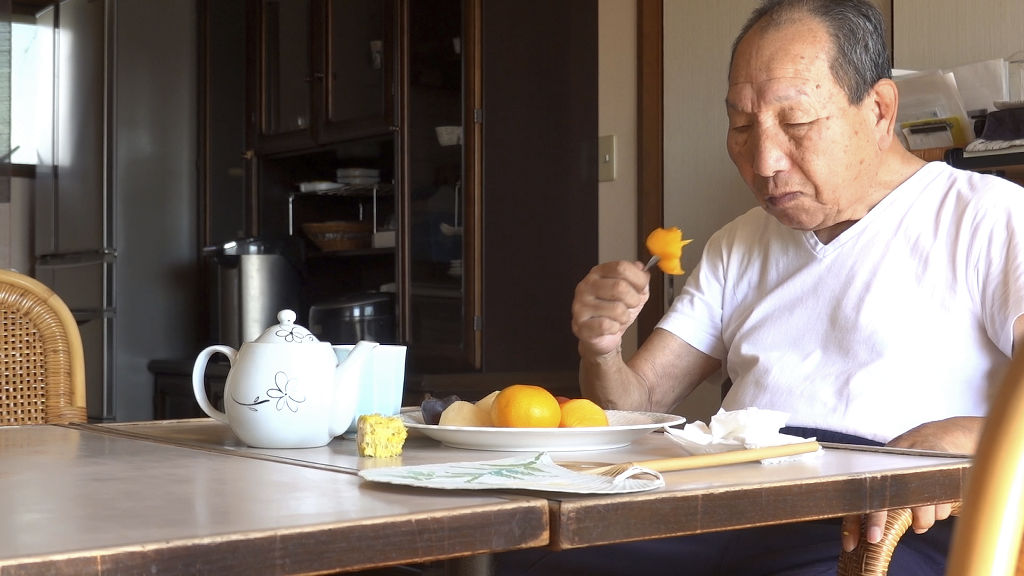 自宅で朝食の果物を味わう袴田巌さん。普段と変わらない１日を過ごした＝２７日午前、浜松市中区（袴田さん支援クラブ提供）
