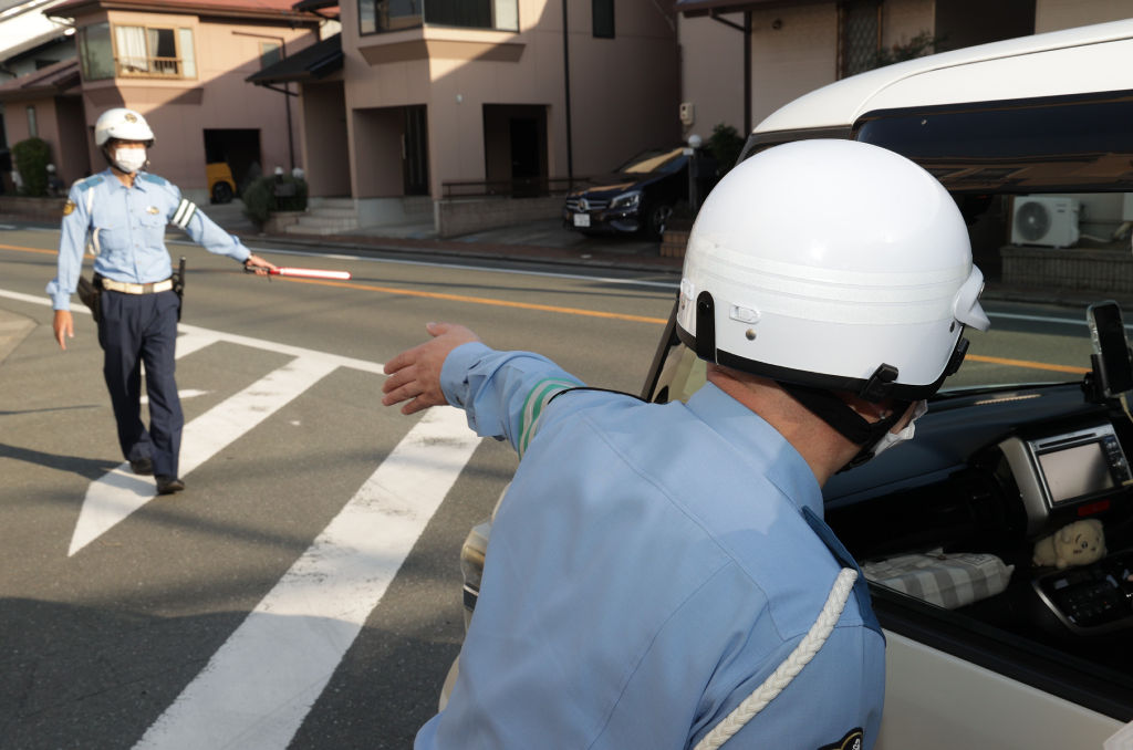 事故現場付近で交通指導を行う警察官＝２７日午後３時１５分ごろ、浜松市南区