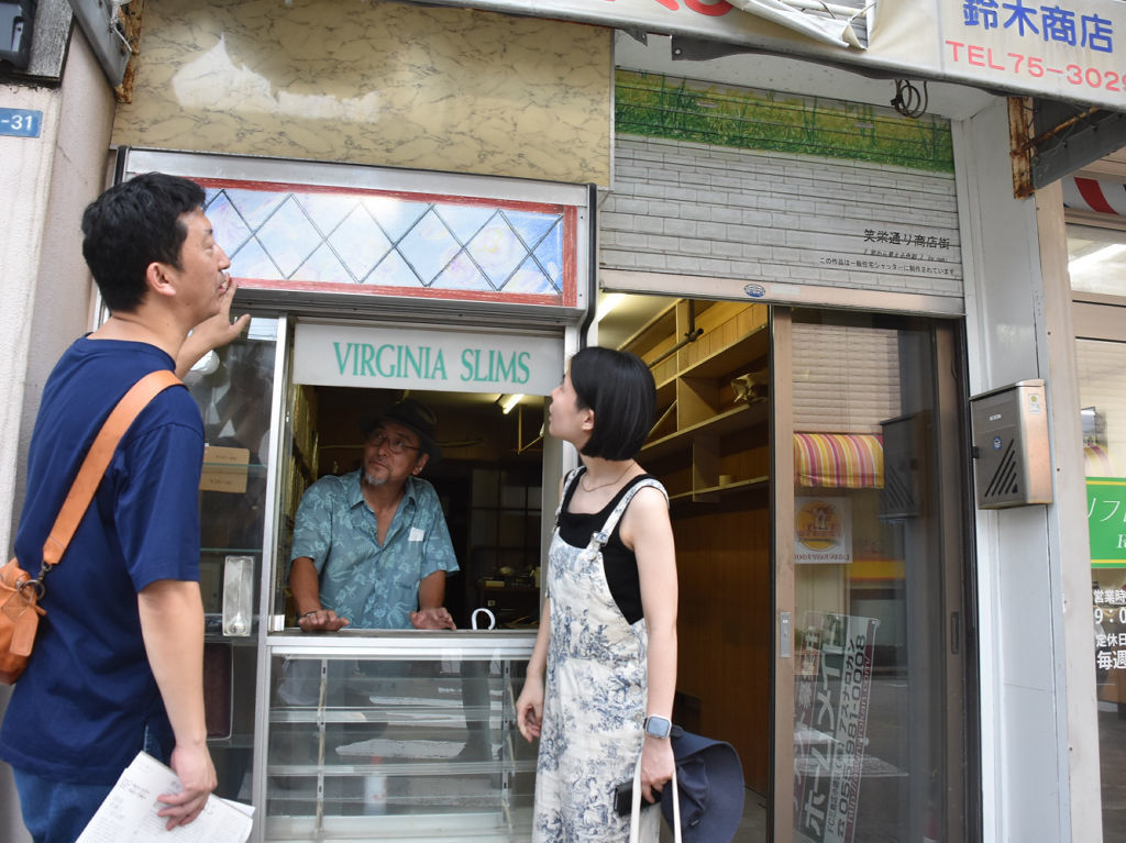 下見に訪れた山本さん（左）に三島の街や店について説明する鈴木さん（左から２人目）＝８月下旬、三島市広小路町