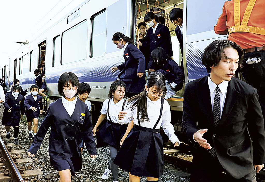 津波避難訓練で列車から降りる小学生ら＝５日午前、和歌山県広川町