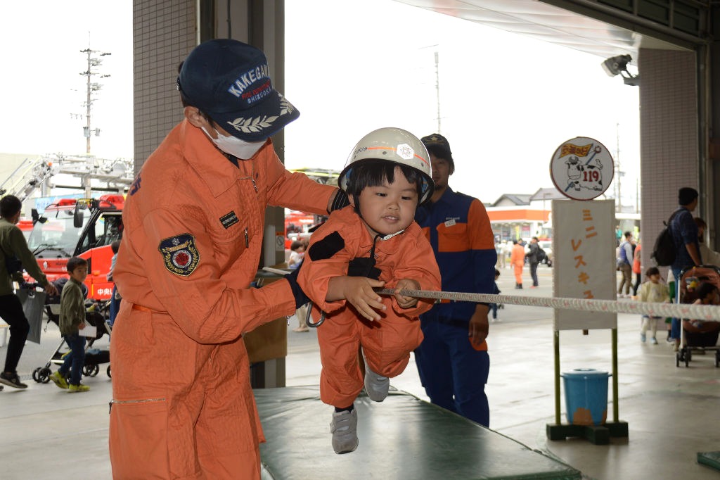 救助服に身を包んで綱を渡る子ども＝掛川市掛川の市中央消防署