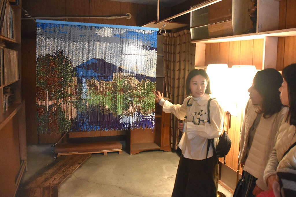富士山をモチーフにした作品を紹介する辻さん（右から３人目）＝三島市広小路町