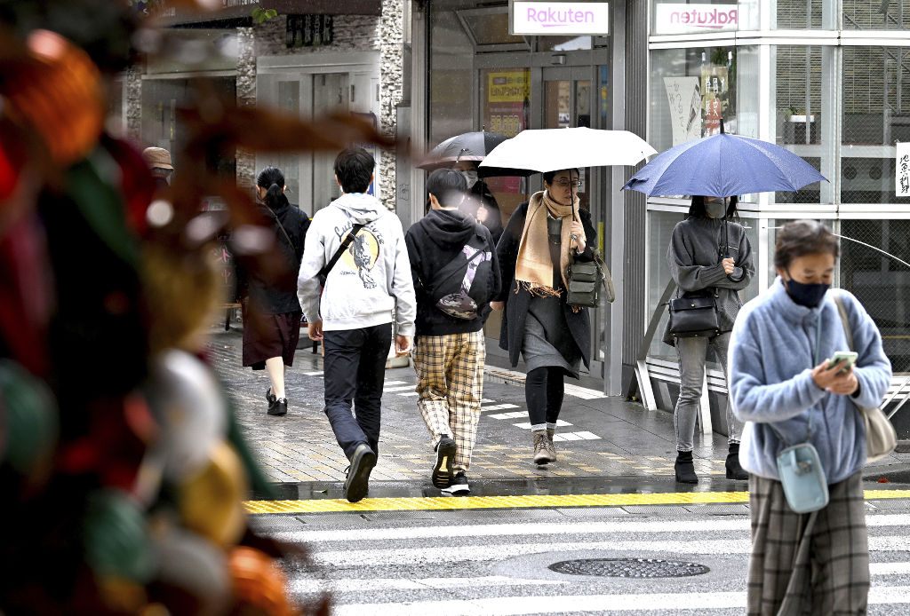 厚手の服やマフラーを身につけ街中をゆく人たち＝１３日午前１０時１８分、静岡市葵区