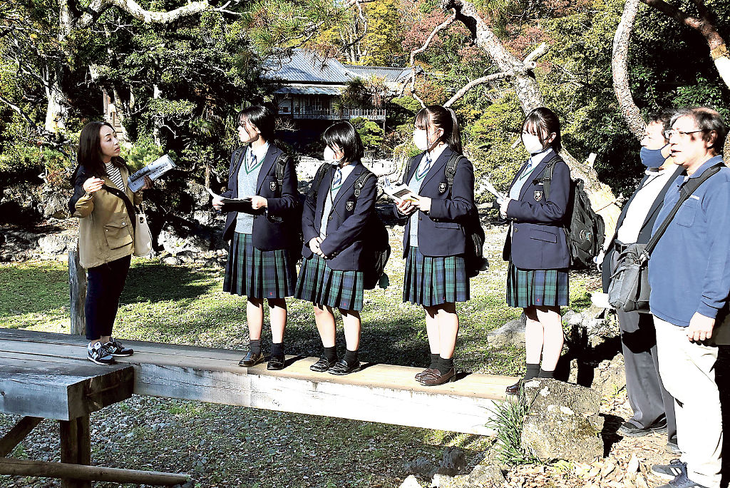 古写真と比較しながら園内を見て回る生徒たち＝三島市の楽寿園