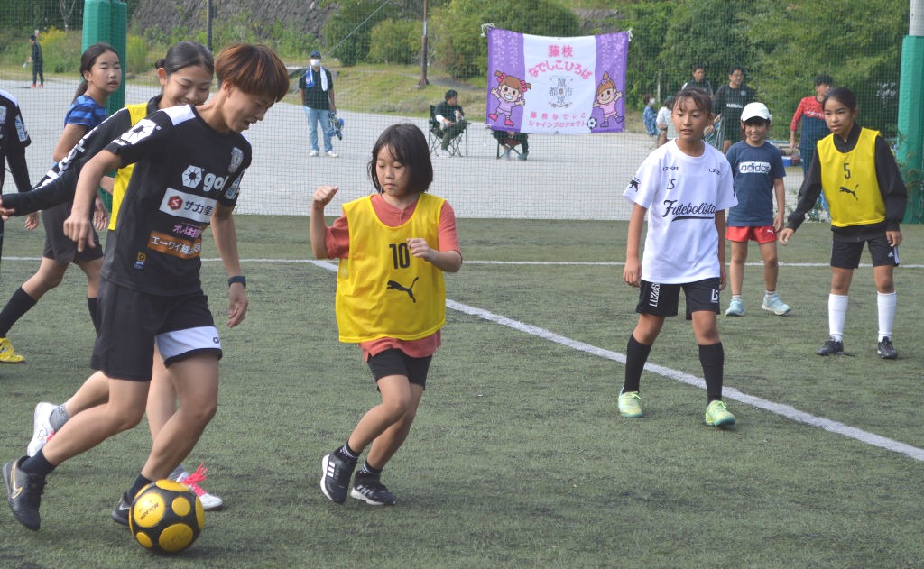 ミニゲームを通じて選手と交流する子どもたち＝１０月、藤枝市の藤枝総合運動公園人工芝グラウンド