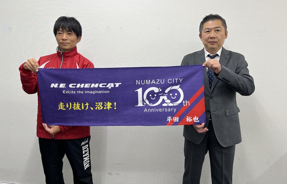 (写説)応援用のタオルを寄贈した佐藤総務部長(右)と平田監督‖沼津市役所