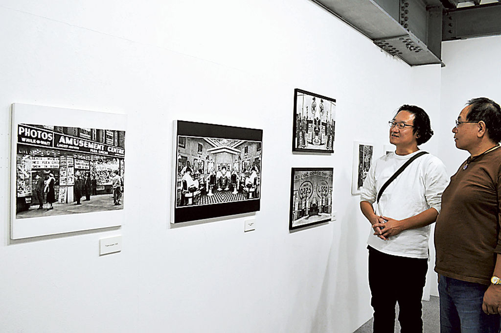 １００年前の写真を基に、細密に描写した鎌田さん（左）の鉛筆画展＝藤枝市小石川町のアートカゲヤマ画廊