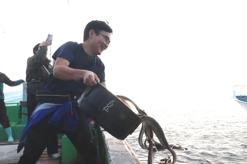 浜名湖で採捕したニホンウナギを沖合に放す会員＝２１日午後、浜松市の遠州灘（代表撮影）