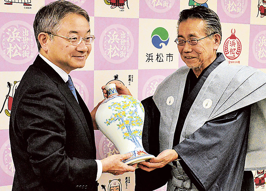 中野市長（左）に鍋島焼の酒器を献上する畑石代表理事＝浜松市役所