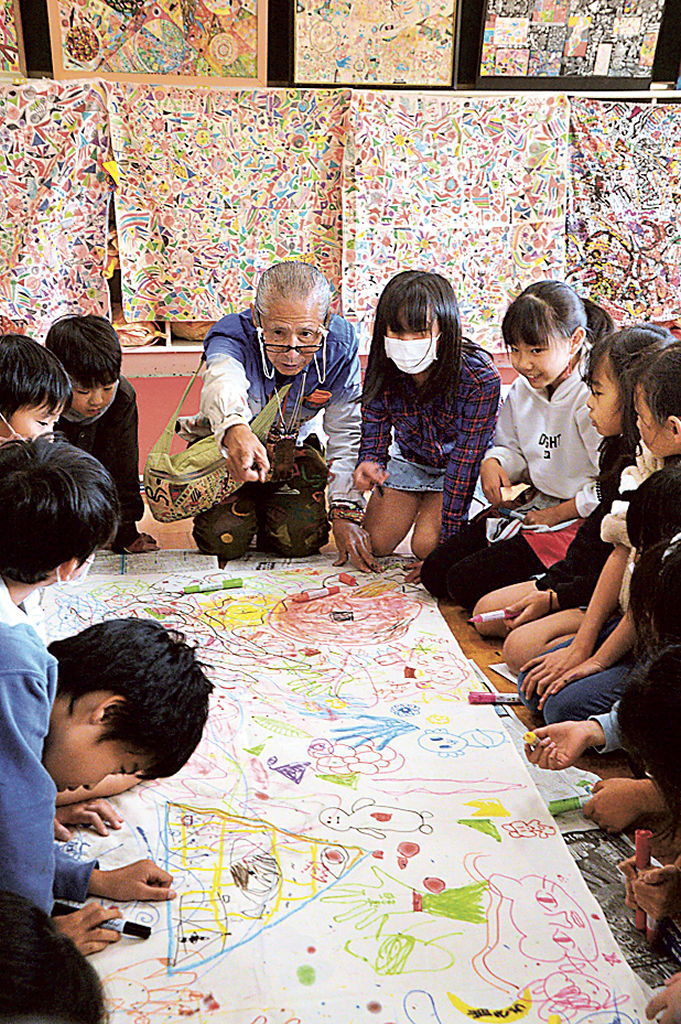 校内の空き教室にできたアトリエで、児童と一緒に創作する本田さん（奥中央）＝沼津市の第四小