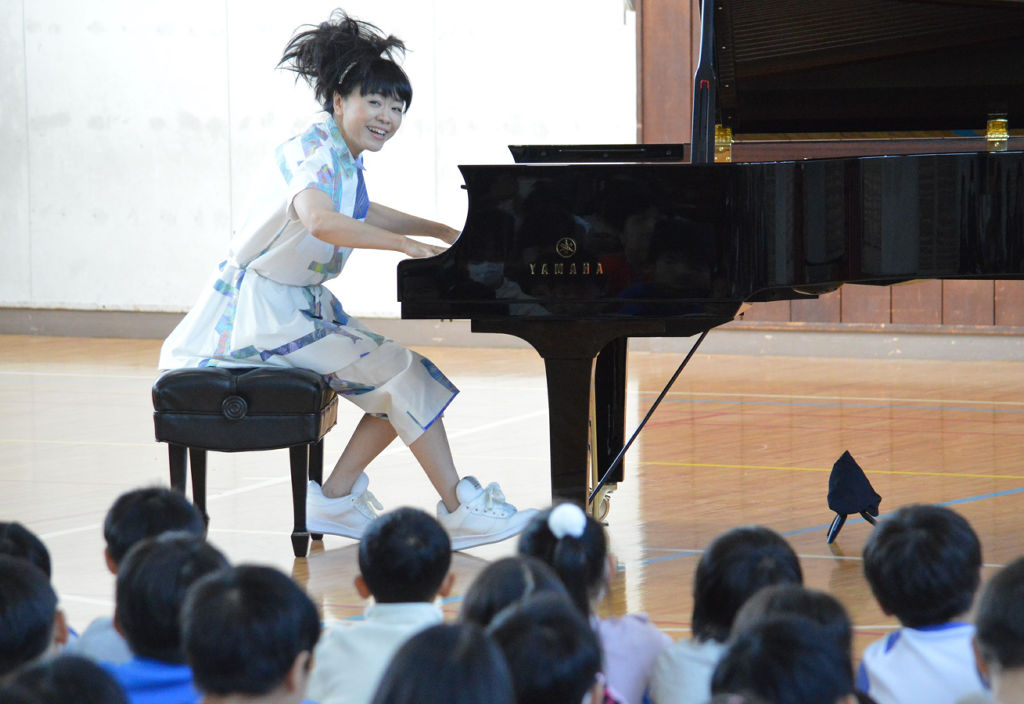 児童の前でピアノ演奏を披露する上原ひろみさん＝浜松市中区の追分小