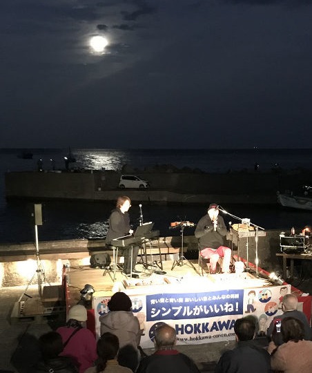 満月に照らされる幻想的なステージが繰り広げられたイベント。地域住民らがテラスから見守った＝東伊豆町のねこさい広場