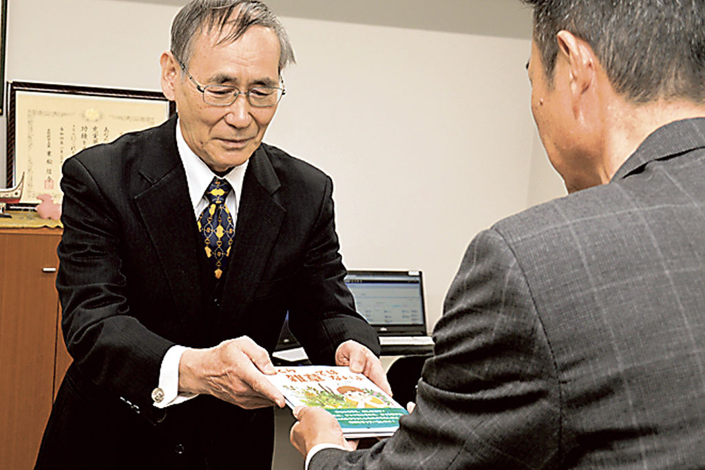 宮崎教育長（右）に絵本を手渡す鈴木さん＝浜松市中区の市教委