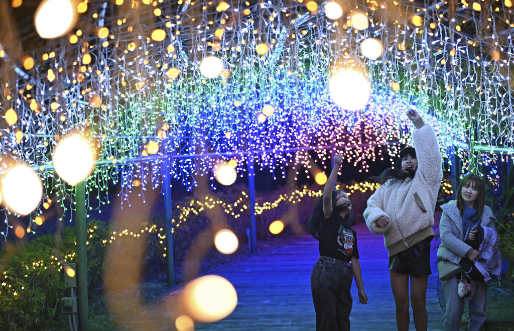 虹色の光のトンネルを楽しむ来園者＝浜松市西区のはままつフラワーパーク