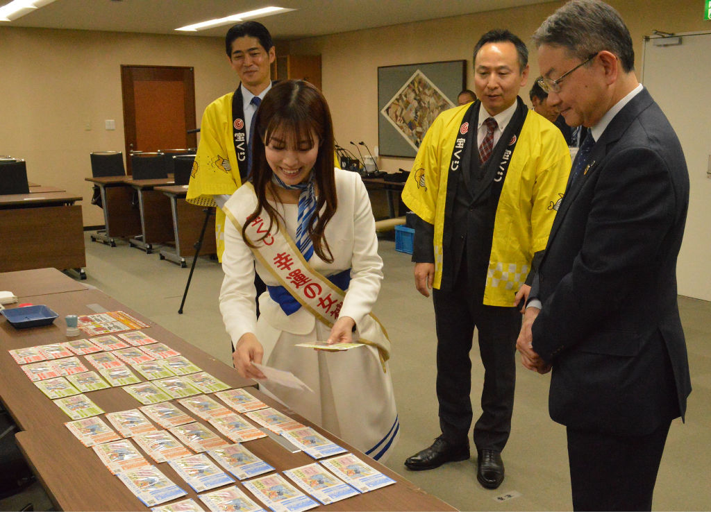 中野市長（右）が購入する宝くじを選ぶ藤田さん＝浜松市役所