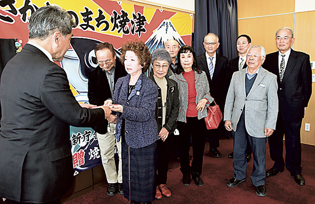 寄付金を渡す新美会長（左から３人目）＝焼津市役所